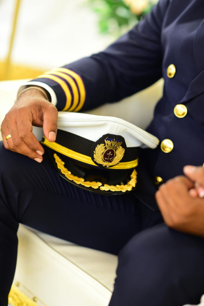 pexels-photo-12437150-12437150 A close-up of a captain in uniform holding a hat, showcasing detailed attire.